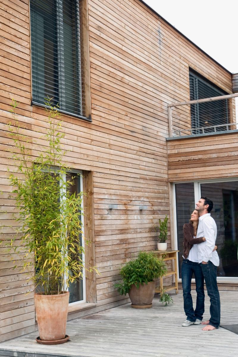 un homme et une femme debout sur une terrasse à côté d'un bâtiment
