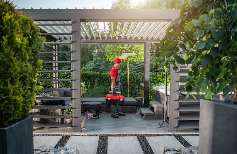 un homme en chemise rouge se tient dans un jardin