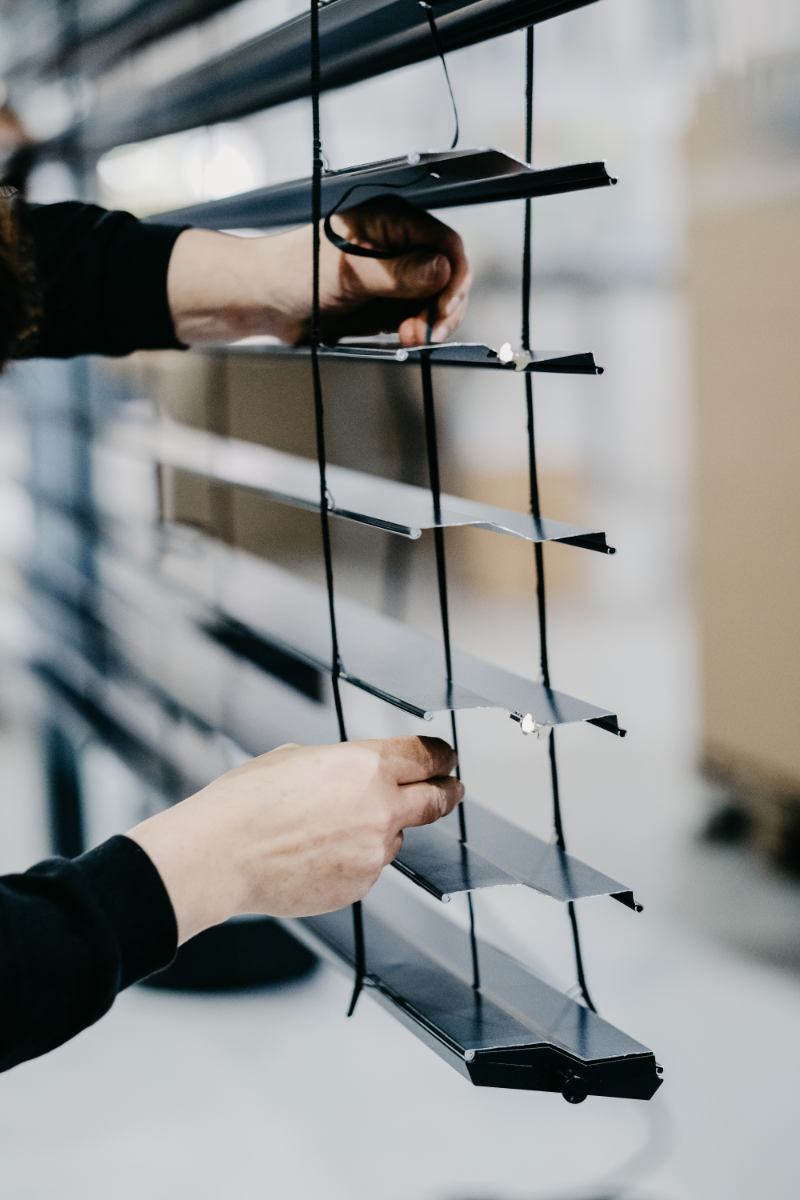 une femme travaille sur un mur avec une paire de ciseaux